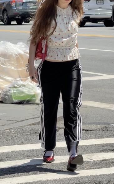 White cherry print peplum top, black striped track pants, and red Mary Jane heels.
