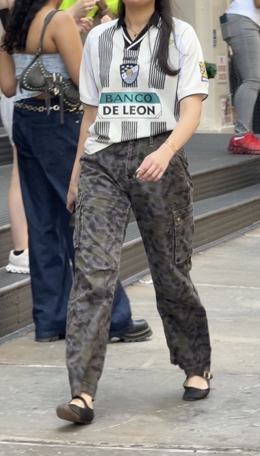 White and black striped polo with camo cargo pants and black flats.