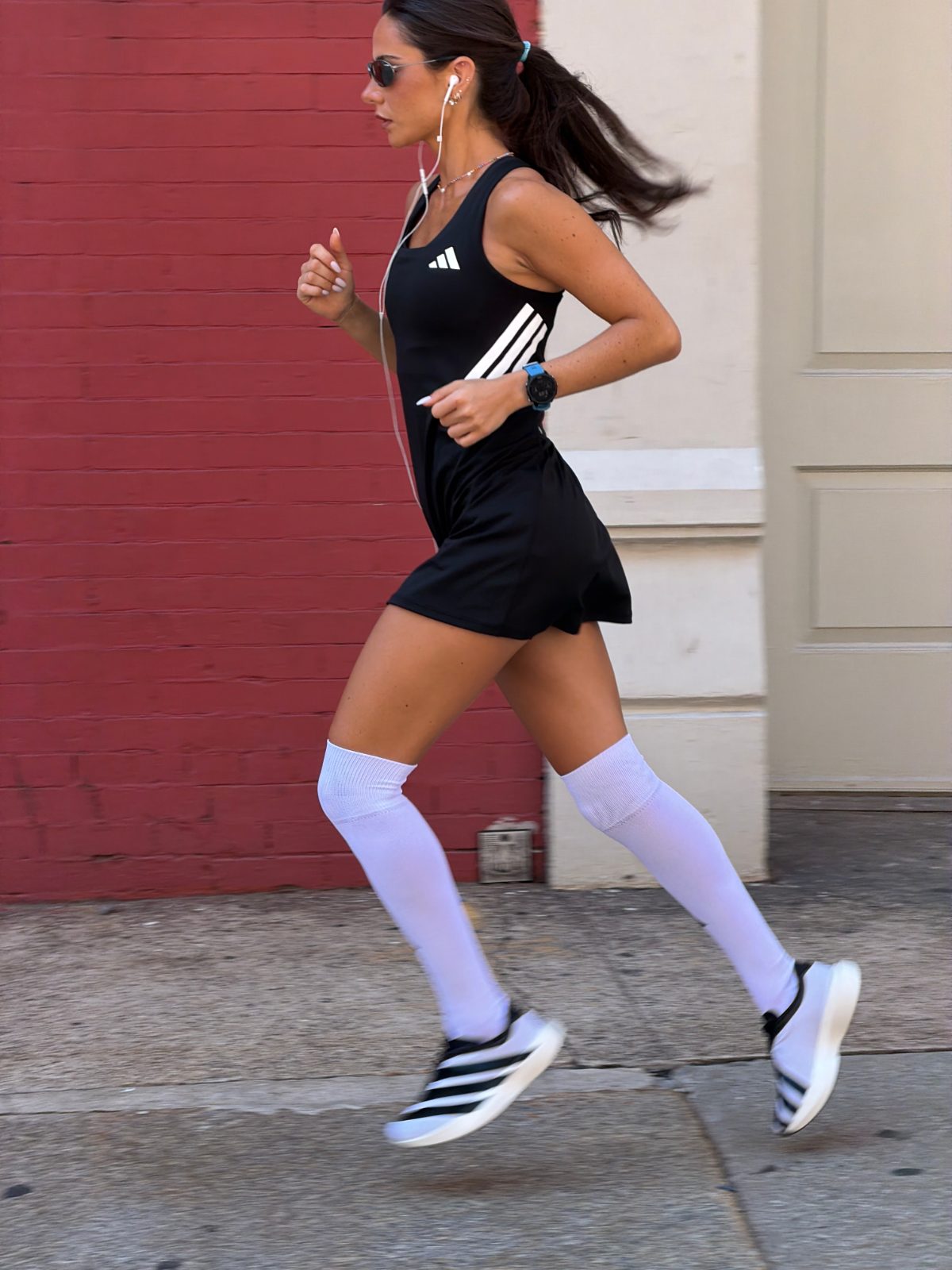 Black Adidas active dress with white stripes, white knee-high socks, and white-soled sneakers.